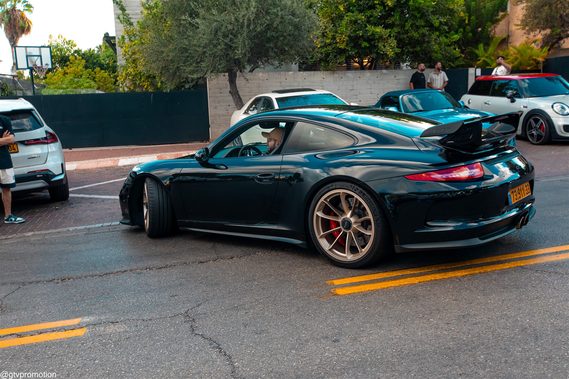 פורשה 911 GT3 כהה עם כנף אחורית גדולה וחישוקים בהירים במפגש צהלה