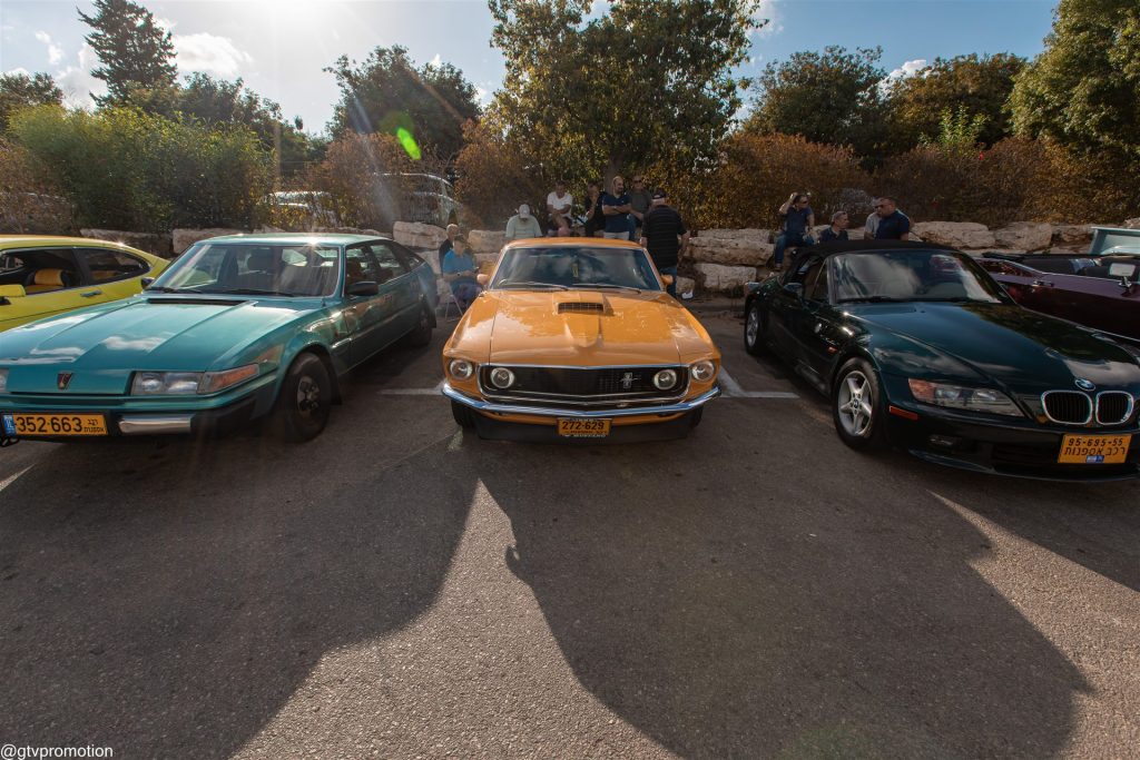 רובר SD1 ירוקה, פורד מוסטנג כתומה ו־BMW Z3 כהה חונות זו לצד זו