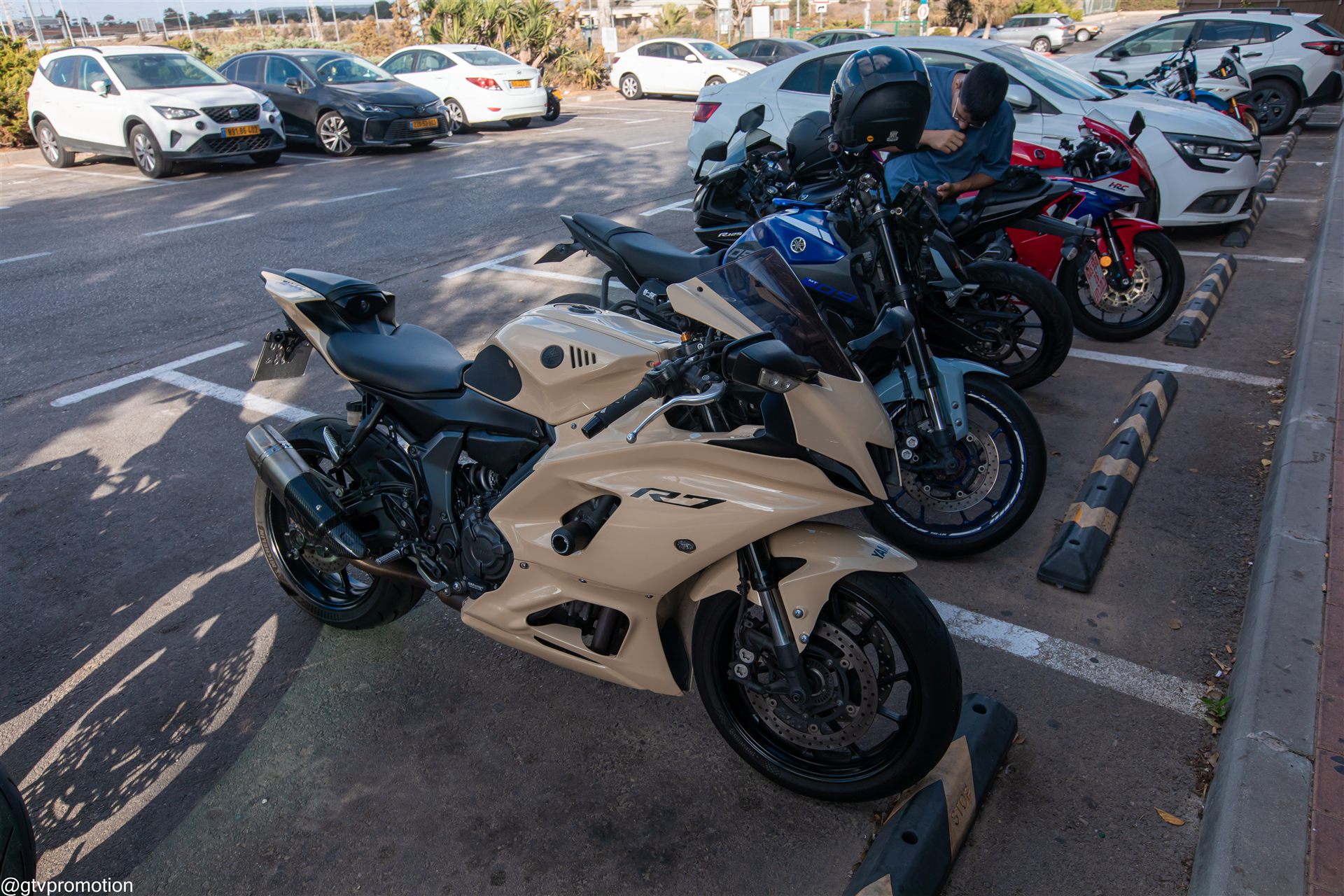 ימאהה R7 בגוון חול בחזית, עם אופנועי ימאהה והונדה מאחוריו