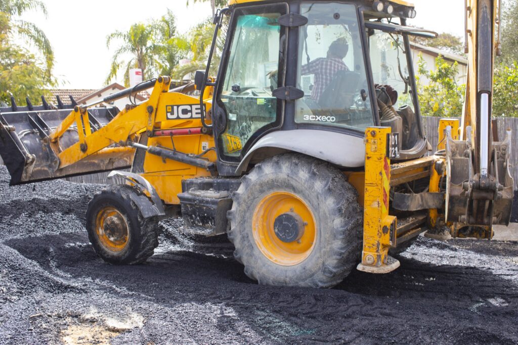 מחפרון JCB על משטח האספלט במהלך עבודות אריאל סחר
