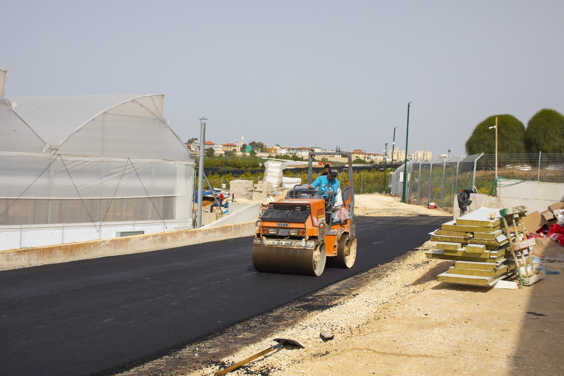 מבט רחב על מכבש ועל דרך אספלט חדשה באתר העבודה של אריאל סחר